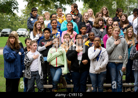 Multicultural group of Texas junior high school students recite Pledge of Allegiance during field trip to rural Milam County TX Stock Photo