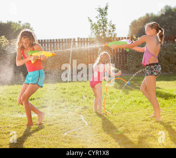 Caucasian girls shooting water guns Stock Photo