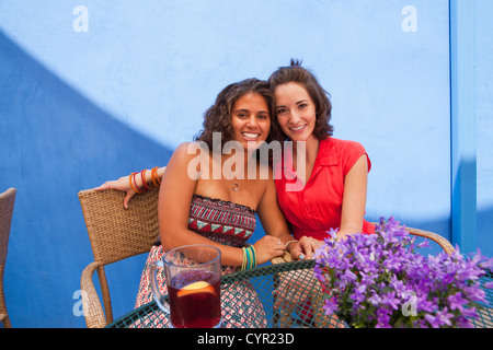 Friends sitting at patio table together Stock Photo