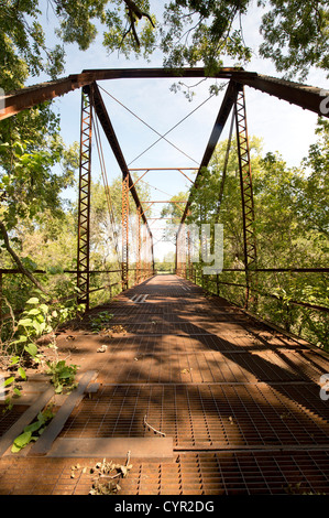 An abandoned one-lane county road and steel truss bridge over the San Gabriel River in central Texas Stock Photo