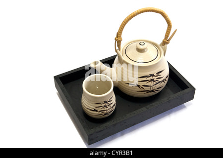 Teapot and teacup painting bamboo leaves on a black tray. Stock Photo