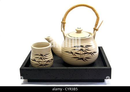 Teapot and teacup painting bamboo leaves on a black tray. Stock Photo