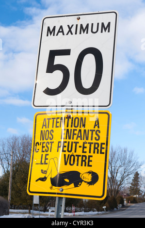 Speed limit 50 and strange French 'caution, children' signs in rural Quebec. Stock Photo