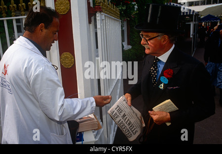 A gentleman buys an edition of the Evening Standard newspaper outside the gates of the Ascot racecourse on Ladies Day Stock Photo