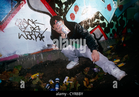 A masked youth is seen after spraying graffiti art on to a wall in the Notting Hill area of West London, England. Stock Photo