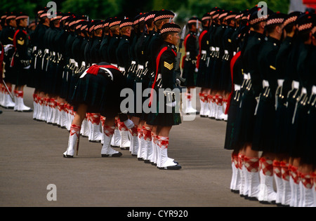 An officer bends down to inspect a soldier within a battalion of Argyll and Sutherland Highlanders at Redford Barracks. Stock Photo