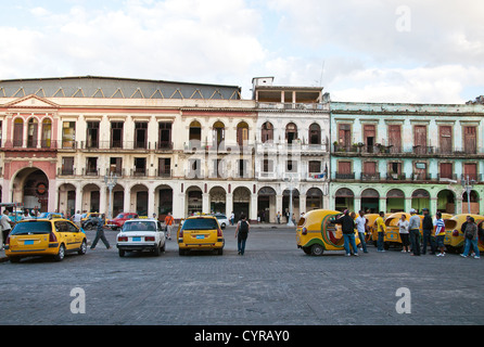 Cocotaxis and crumbling buildings in the background in Havana, Cuba Stock Photo