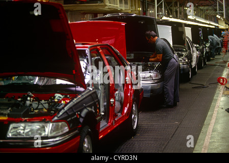 A car worker fits engines on the production line in the German BMW-owned Rover factory in Cowley, Solihull, England. Stock Photo