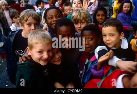 Schoolchildren of many ages and ethnic backgrounds spend their morning break-time in their school playground in London Stock Photo
