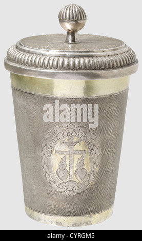 A German snakeskin beaker with coin lid,dated 1723 Silver,partly gilt,slightly conical beaker. The sides finely punched in a snakeskin pattern and,as well as the bottom engraved with three cartouches showing the allegoric symbols for faith,love and hope. Over them inscription scrolls 'Glaube recht an Gott'(Believe in God),'Hoffe fest in Noth'(Hope in times of despair)and 'Liebe bisz in Todt'(Love till death). On the bottom also a monogram with the date 'EP 1723 GH'. The lid with a decorative coin soldered into the centre(a so-called Braunschweiger Lö,Additional-Rights-Clearences-Not Available Stock Photo