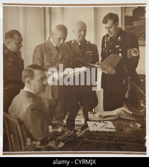 Adolf Hitler,a photograph dedicated to Hans-Heinrich Lammers on occasion of his 60th birthday Large-sized picture(24 x 23.7 cm trimmed?),Hitler sitting at his desk,in front of him Reichsministers Lammers and Frick as well as Reichsleiter Martin Bormann and SS Gruppenführer Wilhelm Stuckart,the lower edge with handwritten ink dedication 'To my assistant,Reichsminister Dr.Lammers,for his 60th birthday and in remembrance of eventful times we went through together - Adolf Hitler.' Well readable autograph applied to picture with bold ink ,Additional-Rights-Clearences-Not Available Stock Photo