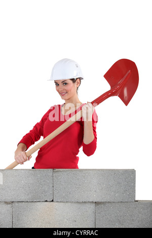 Woman mason holding a shovel Stock Photo