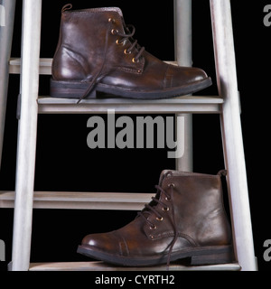 Close-up of leather boots on a step ladder Stock Photo