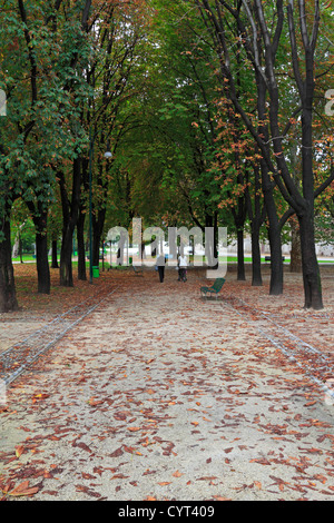 Two people walking down a tree lined path through Parco Sempione in autumn, Milan, Italy, Europe. Stock Photo