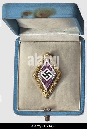 Adolf Hitler,a golden Hitler Youth Honour Badge with brilliants and rubies in an oak leaf wreath Gold(hallmark '585'),platinum,brilliants and rubies. No maker's mark. In a light-blue leather case with white velvet and silk lining. Included is the document tube for the award document,a white leather cylinder with stamped National Eagle above a Hitler Youth emblem and continuous gold-stamped meander bands. The tube is in its corresponding oak wooden casket with brown v historic,historical,1930s,20th century,NS,National Socialism,Nazism,Third Reich,Ge,Additional-Rights-Clearences-Not Available Stock Photo