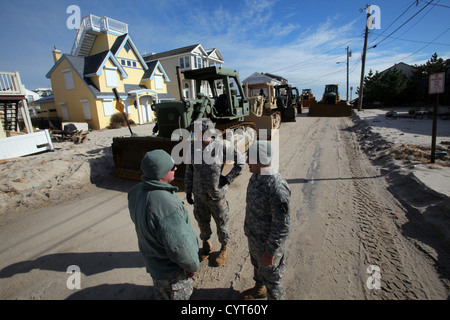 Soldiers from the 150th and 160th Engineer Companies, New Jersey Army National Guard, discuss movement options for their D7 bulldozers prior to performing beach replenishment operations Nov. 8, 2012, in the devastated Holgate section of Long Beach Island, Stock Photo