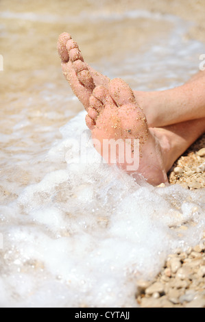 Relaxation on beach, detail of male feet Stock Photo