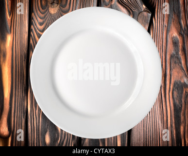 White plate on a dark wooden table Stock Photo