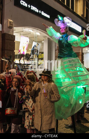 Bristol, UK. 9th November 2012. A procession of Lost Boy drummers and 150-strong procession of youth theatre school children dance their way from The Galleries to Cabot Circus. Bristol-based Cirque Bijou featuring acrobatics, stilt walkers and jugglers entertain crowds before the Christmas lights are illuminated. Stock Photo