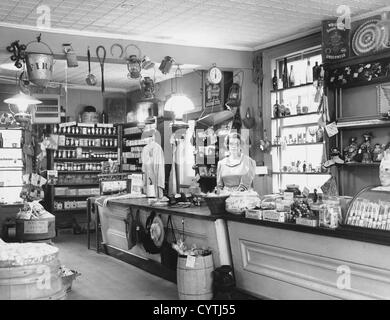 Woman working behind counter of general store Stock Photo