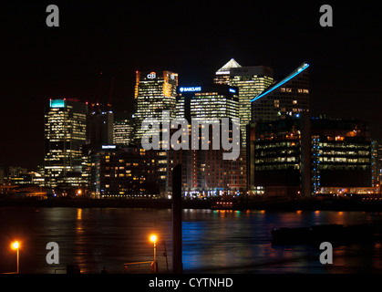 Night view of Canary Wharf skyline from Trinity Buoy Wharf showing the River Thames in foreground, London, England, UK Stock Photo