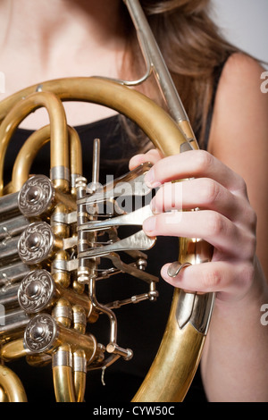 detail of a female musician´s fingers playing concert french horn Stock Photo