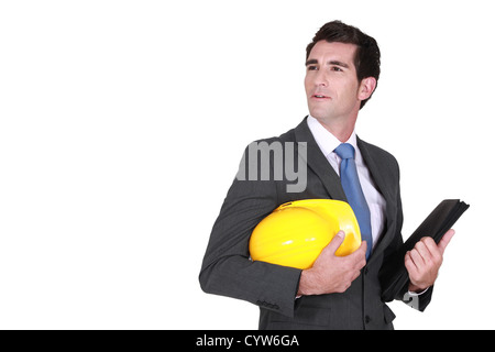 Man in a suit and helmet with folder Stock Photo