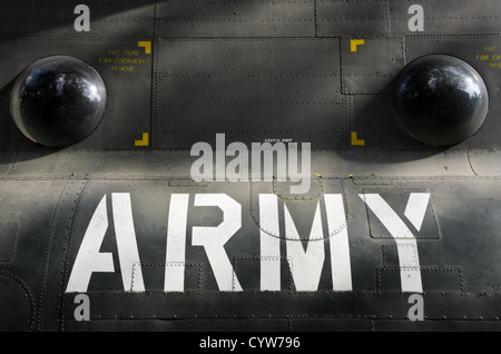 HO CHI MINH CITY, Vietnam — The 'ARMY' stencil lettering appears on the exterior of a CH-47 Chinook helicopter at the War Remnants Museum. The military typography represents standard US Army aircraft identification markings from the Vietnam War era. The helicopter stands among other military artifacts in the museum's outdoor exhibition area. Stock Photo