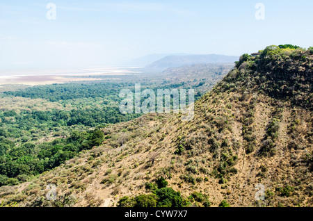 LAKE MANYARA NATIONAL PARK, Tanzania - A view out over Lake Manyara National Park from an elevated point just outside the park. At right, on the top of the headland, is one of the luxury resorts. The park, known for tree-climbing lions and flamingos, plays a crucial role in the conservation of Tanzania's diverse species and ecosystems. Stock Photo