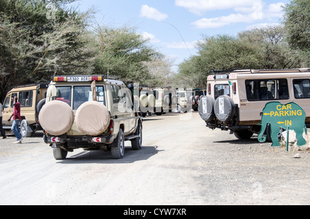 TARANGIRE NATIONAL PARK, Tanzania - Safari vehicles lined up in the parking lot at the main entrance to Tarangire National Park in northern Tanzania not far from Ngorongoro Crater and the Serengeti. The Ngorongoro Crater, a UNESCO World Heritage Site, is a vast volcanic caldera in northern Tanzania. Created 2-3 million years ago, it measures about 20 kilometers in diameter and is home to diverse wildlife, including the 'Big Five' game animals. The Ngorongoro Conservation Area, inhabited by the Maasai people, also contains significant archaeological sites like Olduvai Gorge and Laetoli, which o Stock Photo