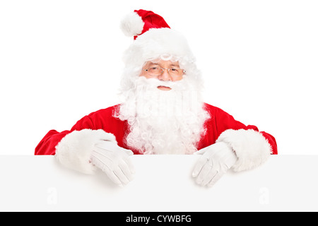 Santa Claus posing behind a blank billboard isolated on white background Stock Photo