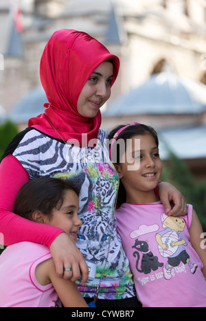 woman in red scarf with two children, Mawlana Jalal al-Din Rumi complex, Konya, Turkey Stock Photo