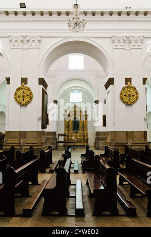 GUATEMALA CITY, Guatemala — The ornate interior of Catedral Metropolitana Santiago de Guatemala. Towering columns support vaulted ceilings adorned with intricate frescoes, while gilded altars and religious artwork line the nave, showcasing the cathedral's blend of neoclassical and baroque styles. Stock Photo