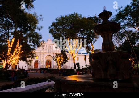 ANTIGUA GUATEMALA, Guatemala — Strings of lights are wrapped around the trees in the central town square in Antigua Guatemala. Famous for its well-preserved Spanish baroque architecture as well as a number of ruins from earthquakes, Antigua Guatemala is a UNESCO World Heritage Site and former capital of Guatemala. Stock Photo