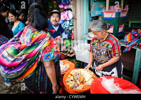 ANTIGUA, Guatemala - A woman sells various snacks and grains at the main market in Antigua, Guatemala. Stock Photo