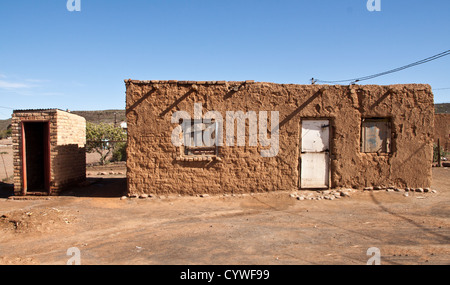 Mud hut complete with the long drop toilet to the side, they even have a phone. This is in Van Wyksvlei Northern Cape SA. Stock Photo