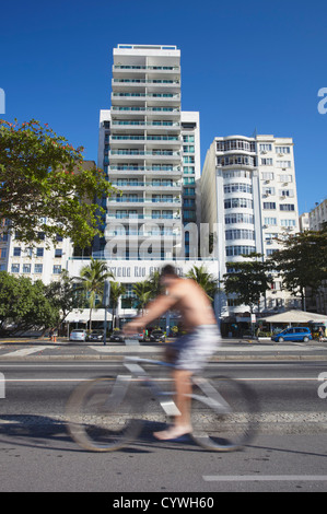 Cyclist passing Pestana Rio Atlantica Hotel on Avenida Atlantica, Copacabana, Rio de Janeiro, Brazil Stock Photo