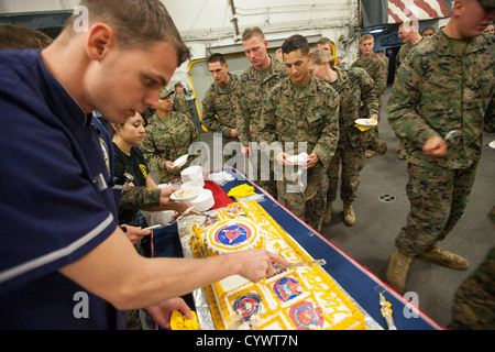A birthday cake is shared with Marines and sailors aboard the USS Wasp