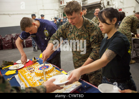 A birthday cake is shared with Marines and sailors of the 26th MEU