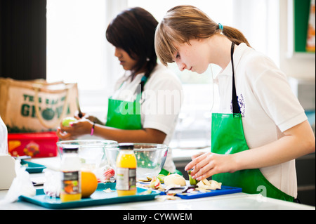 Two girls preparing vegetables in a food technology cookery class at a secondary school, Wales UK Stock Photo