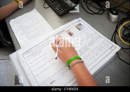 Pupils writing in their design technology workbooks at a comprehensive secondary school Wales UK Stock Photo