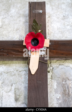 Red poppy attached to a wooden cross on remembrance day UK Stock Photo