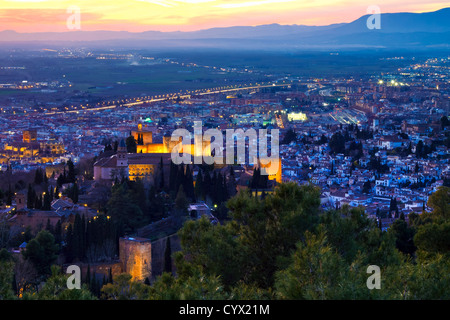 Alhambra palace by floodlight at sunset with Cathedral, Albaicin district and Vega in background skyline. Granada, Spain Stock Photo