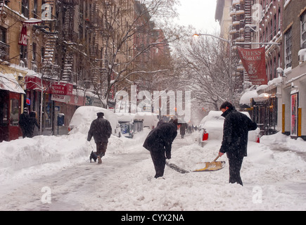 New Yorkers shovel snow and walk in the streets during a record snowstorm Stock Photo