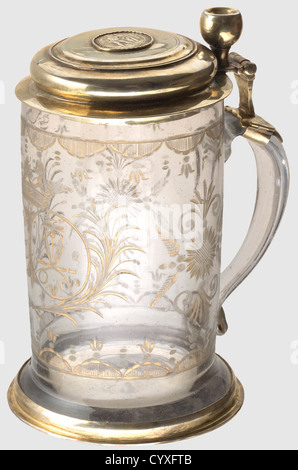 German Tailor's splendid glass tankard,around 1730 A cylindrical mug of discoloured glass with a protruding base and a flat handle on side.Rich gilded cut decoration.There is a crowned double cartouche in centre containing monogram 'JGC' and symbols of a tailor's craft : shears,pressing iron,and yardstick,surrounded by decorative blooms and garlands.Fire-gilded silver mountings.There is a Brunswick Vierteltaler coin set into lid showing a woodwose and dated 1664.The master's mark 'IKS' is stamped on rim of lid along with,Additional-Rights-Clearences-Not Available Stock Photo