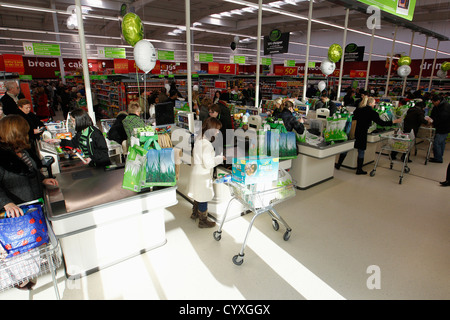 Busy check outs with queueing customers British Isles Great Britain Northern Europe Shop Shops Shoppers Mall Retail Buy Buying Stock Photo