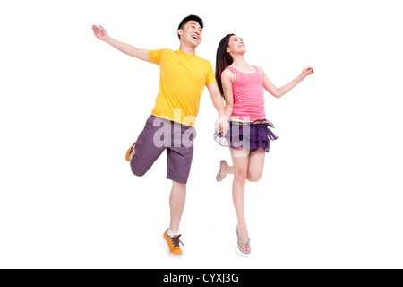 Excited young couple running hand in hand Stock Photo
