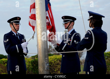 Members of the Kadena Honor guard step to raise the American flag as reveille sounds during the Veterans Day ceremony at the 18th Wing Headquarters building on Kadena Air Base, Japan, Nov. 12, 2012. After the raising of the flag and the Japanese and Ameri Stock Photo