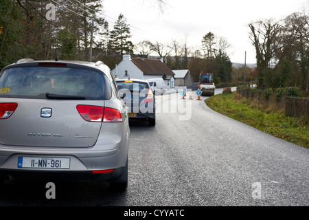 cars waiting in traffic due to roadworks on a country road in the republic of ireland Stock Photo