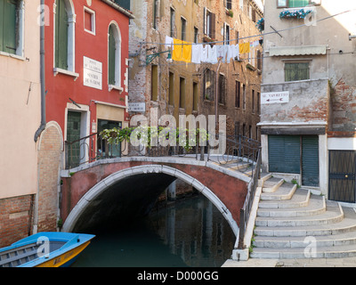 Italy, Venice, Ponte de la Chiesa: pretty bridge with steps, hanging washing and Al Vaporetto sign Stock Photo